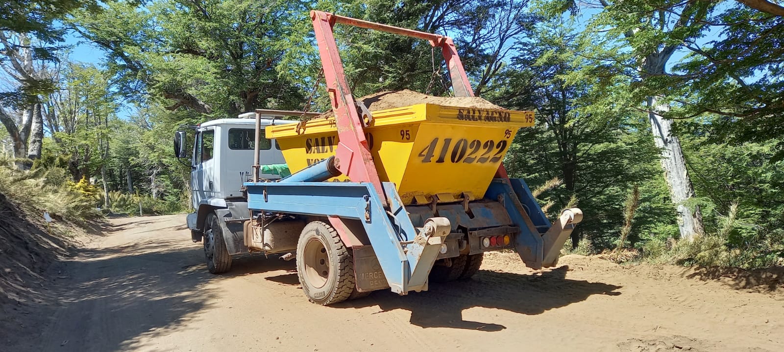 Camión de Salvagno con un volquete cargado de áridos en un camino de bosque de la cordillera