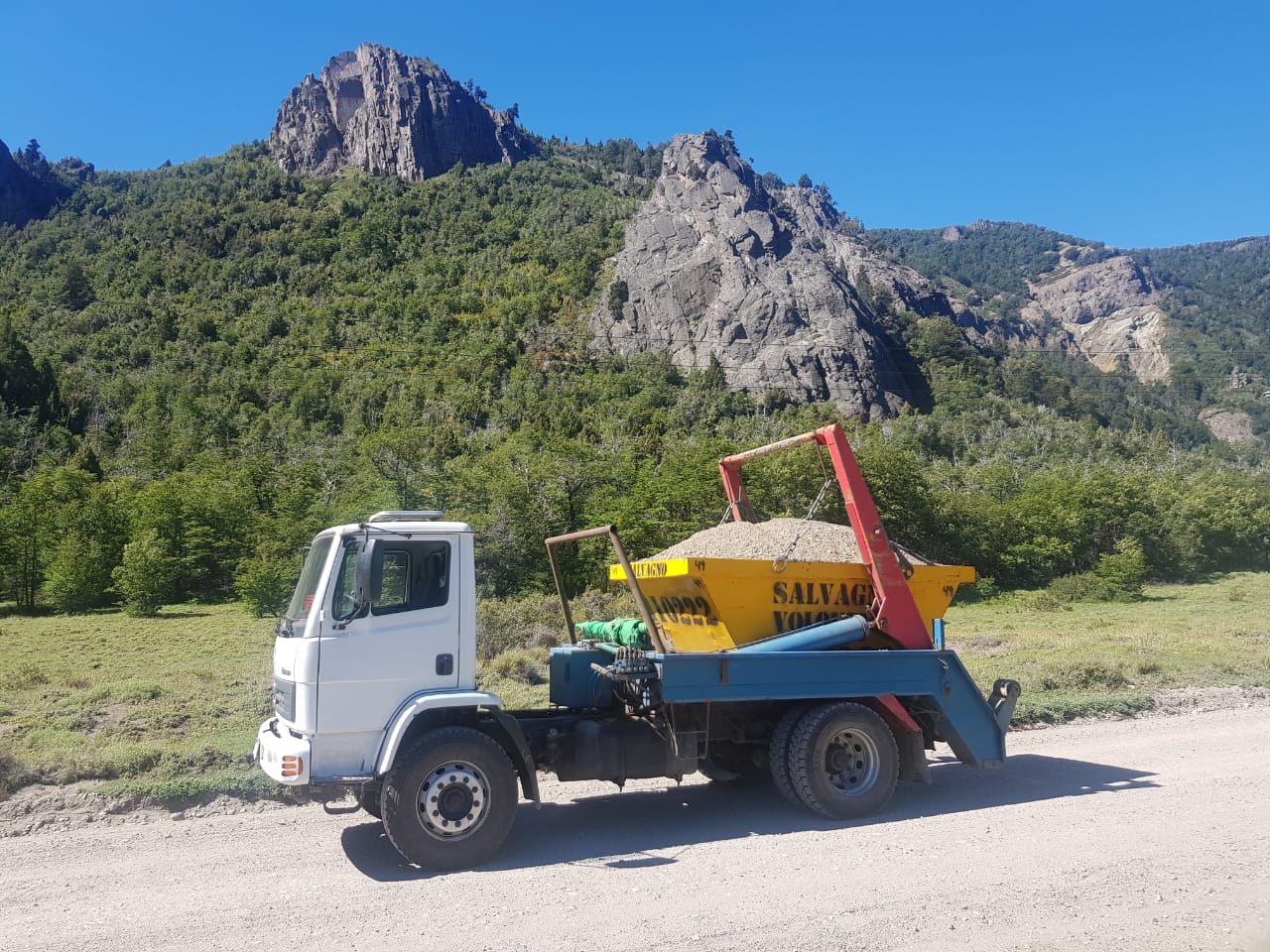 Camión de Salvagno con un volquete cargado y un cerro rocoso